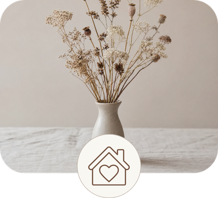 A feminine wooden head sculpture vase filled with a bouquet of dried white flowers and botanical elements, centered on a textured beige linen fabric background.