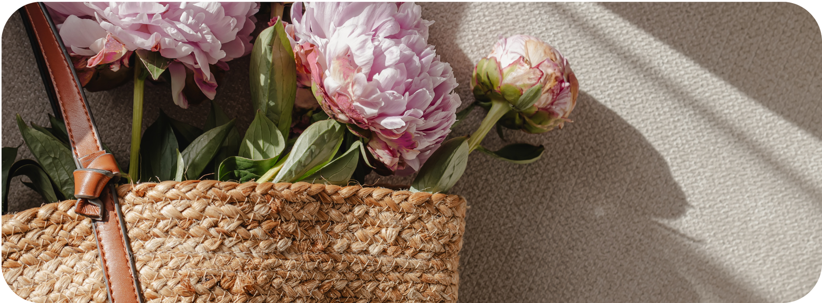 Pink flowers in a woven basket with soft sunlight for gentle grounding and sensory calm